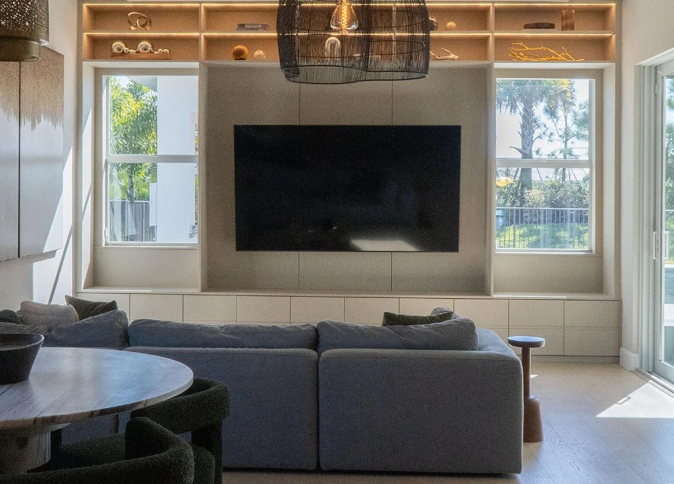Built-in media wall with custom storage cabinetry and illuminated display shelves