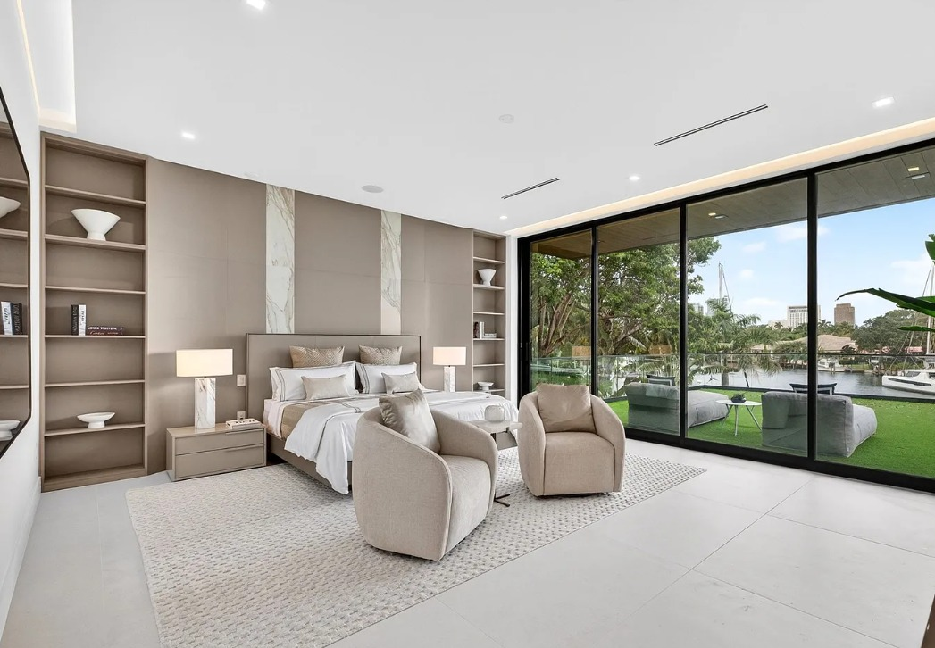 Bedroom with custom built-in shelving, wall panels, and storage cabinetry
