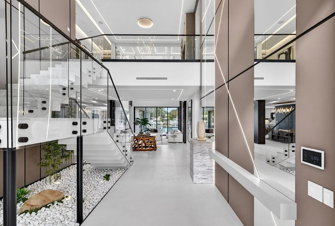 Modern glass stair entry with custom wall panels and linear accent lighting
