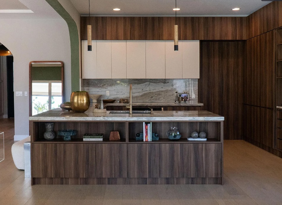 Rich wood kitchen island with custom cabinetry, open shelving, and stone surfaces