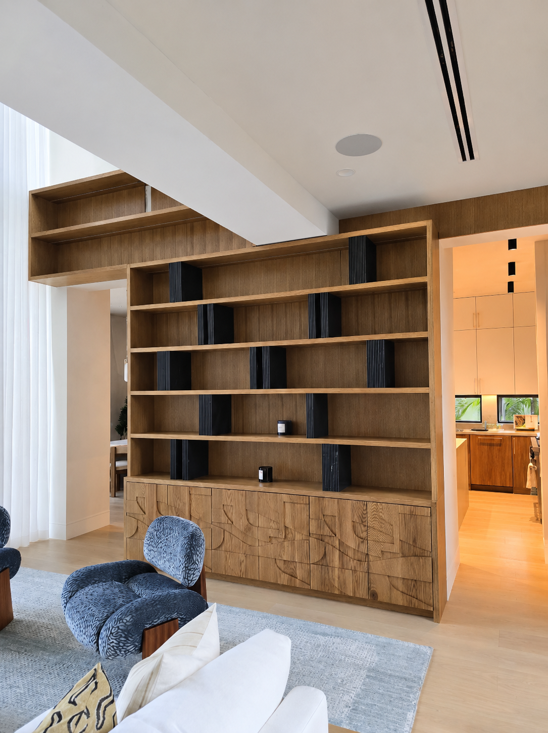 Architectural wood display wall with custom shelving and textured cabinet fronts